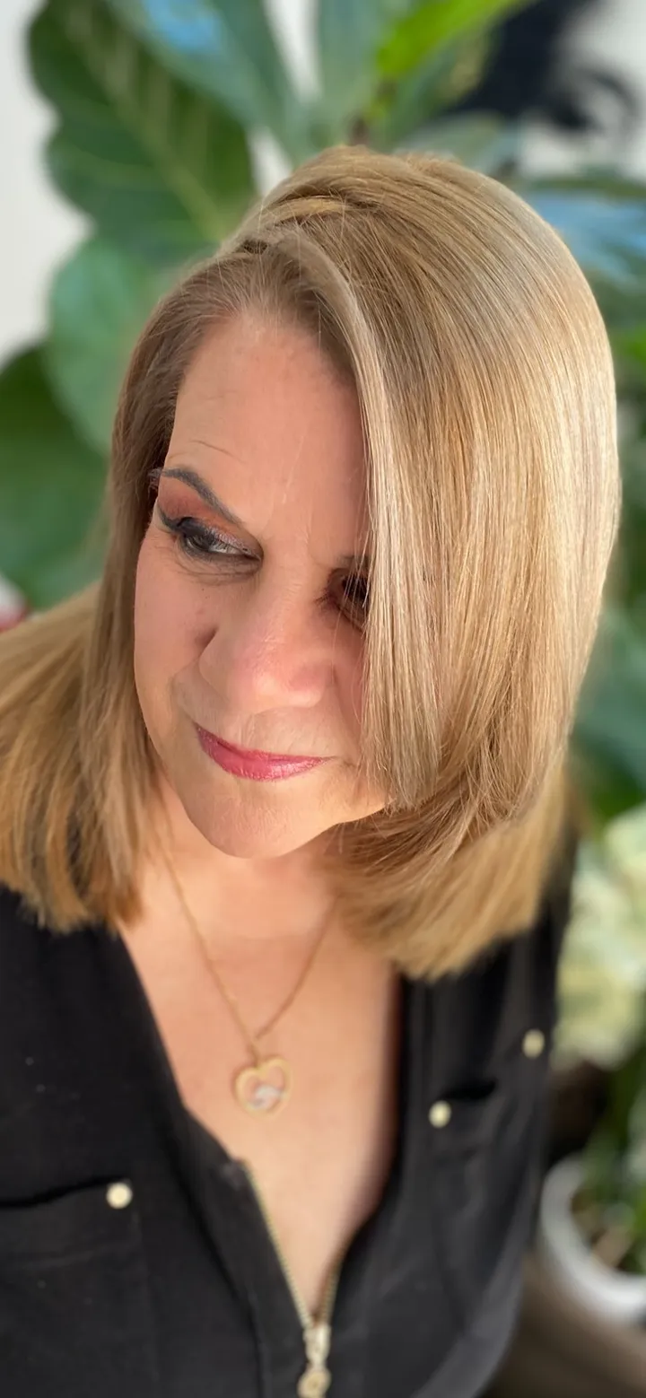 Shoulder-length blonde bob with a sleek blow-dry finish and warm dimensional color